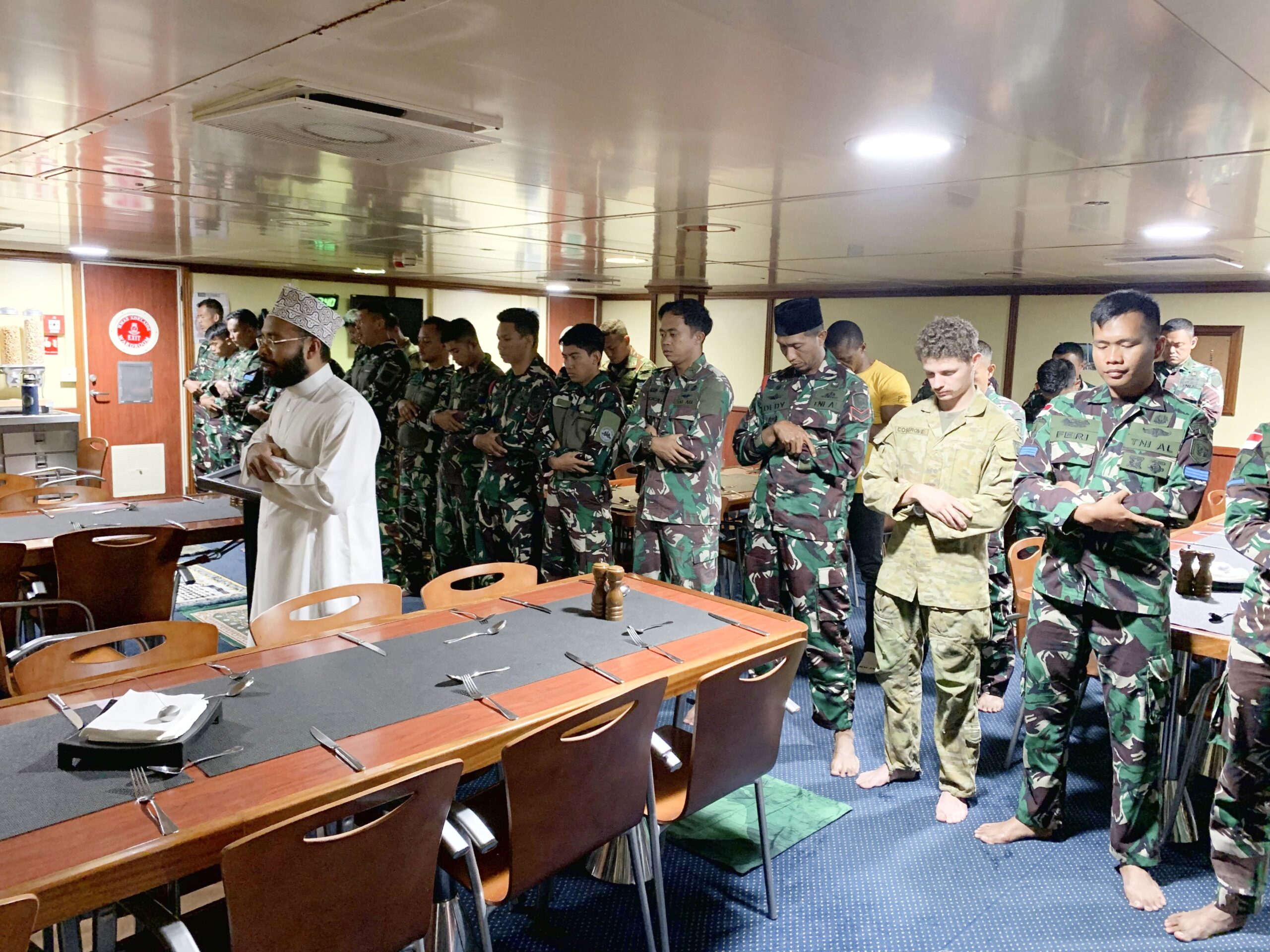 Meski sedang berlayar di laut lepas, bukan suatu halangan bagi prajurit TNI untuk melaksanakan ibadah sholat Jumat berjamaah bersama beberapa prajurit muslim ADF, bertempat di Wardroom, HMAS Adelaide. (Sumber foto Puspen TNI)